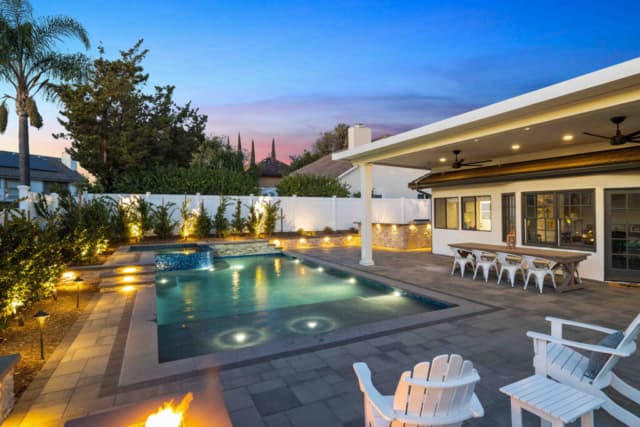 Rectangular pool in a landscaped backyard in the evening